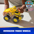 PAW Patrol Rubble truck toy shows bright yellow plastic body with textured mud graphics, large rubber-like wheels, and front roller attachment, demonstrated in a child’s hands on a tabletop play setting.