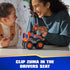 PAW Patrol Zuma hovercraft toy shows bright orange plastic body with smooth and textured panels, chunky oversized wheels, and clip-in driver seat feature, used by child and adult on a tabletop indoor setting.