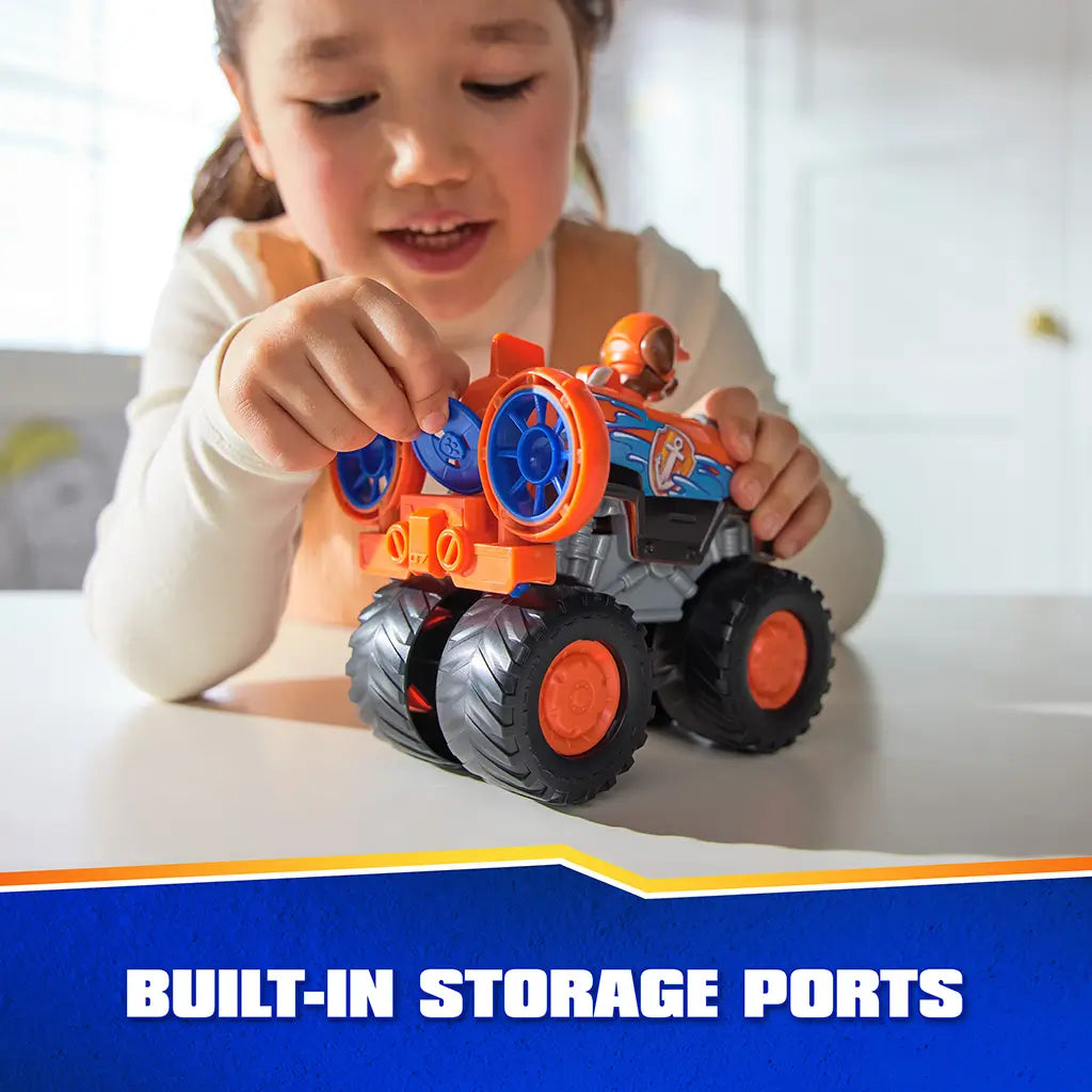 PAW Patrol Zuma hovercraft toy includes bright orange plastic body with smooth texture, built-in storage ports, oversized wheels, and rear fan detail, shown in child’s hands during indoor play activity.
