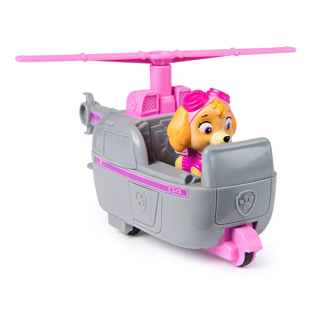 Angled view of Paw Patrol Skye helicopter toy with Skye pup seated in cockpit, gray body with pink accents, paw badge details, and large pink rotor on top.