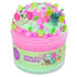 Pink and green cloud dough slime with a smooth, fluffy texture, decorated with axolotl figurines, flower confetti, leaf sprinkles, and pearls, packaged in a jar labeled Axolotl Garden.