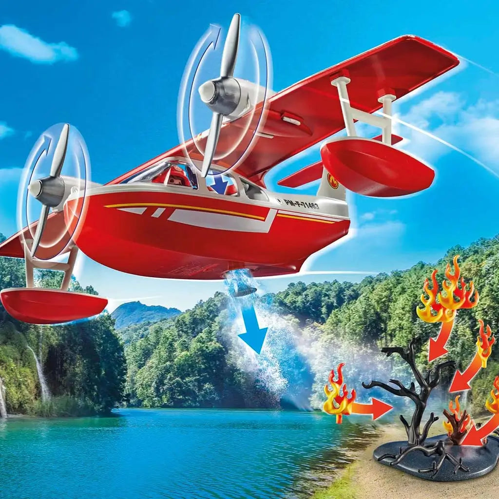 Playmobil firefighting seaplane soaring above a vivid blue lake with spinning propellers as a water drop effect targets rising flames near a dark tree in a lush forest setting.