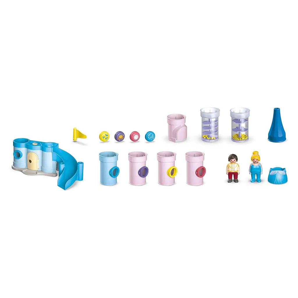 All Playmobil Disney castle components are displayed in neat rows, showing pastel tubes, connector pieces, spiral-ramp canisters with yellow beads, small character figures, and castle accessories for modular building.