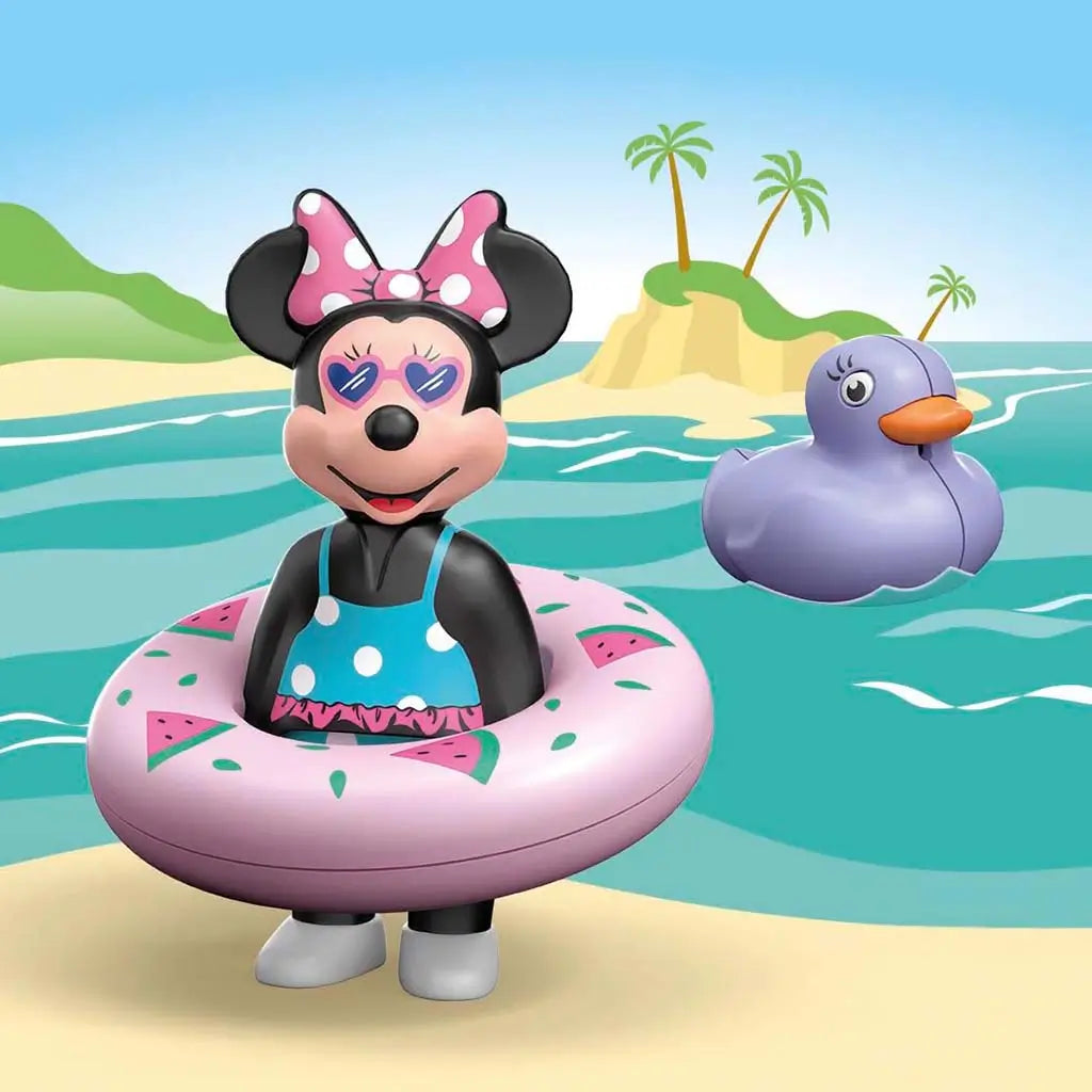 Playmobil Disney Minnie Mouse beach scene shows Minnie in pink watermelon float on sandy shore with calm waves and purple duck nearby beside small island with palm trees.