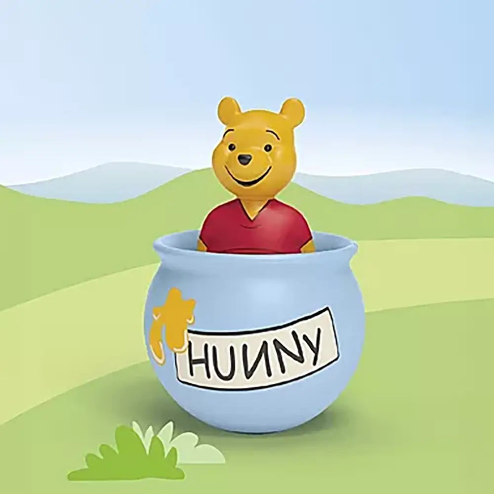 Playmobil Winnie the Pooh figure rising from a blue honey pot shown in a soft green landscape with rolling hills and pale sky, highlighting gentle colors and toddler-friendly shapes for playful scenes.