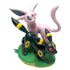 Pokémon TCG Espeon and Umbreon collectible figure in pink and black molded plastic with yellow ring accents, posed together on a green base against a clean white backdrop.