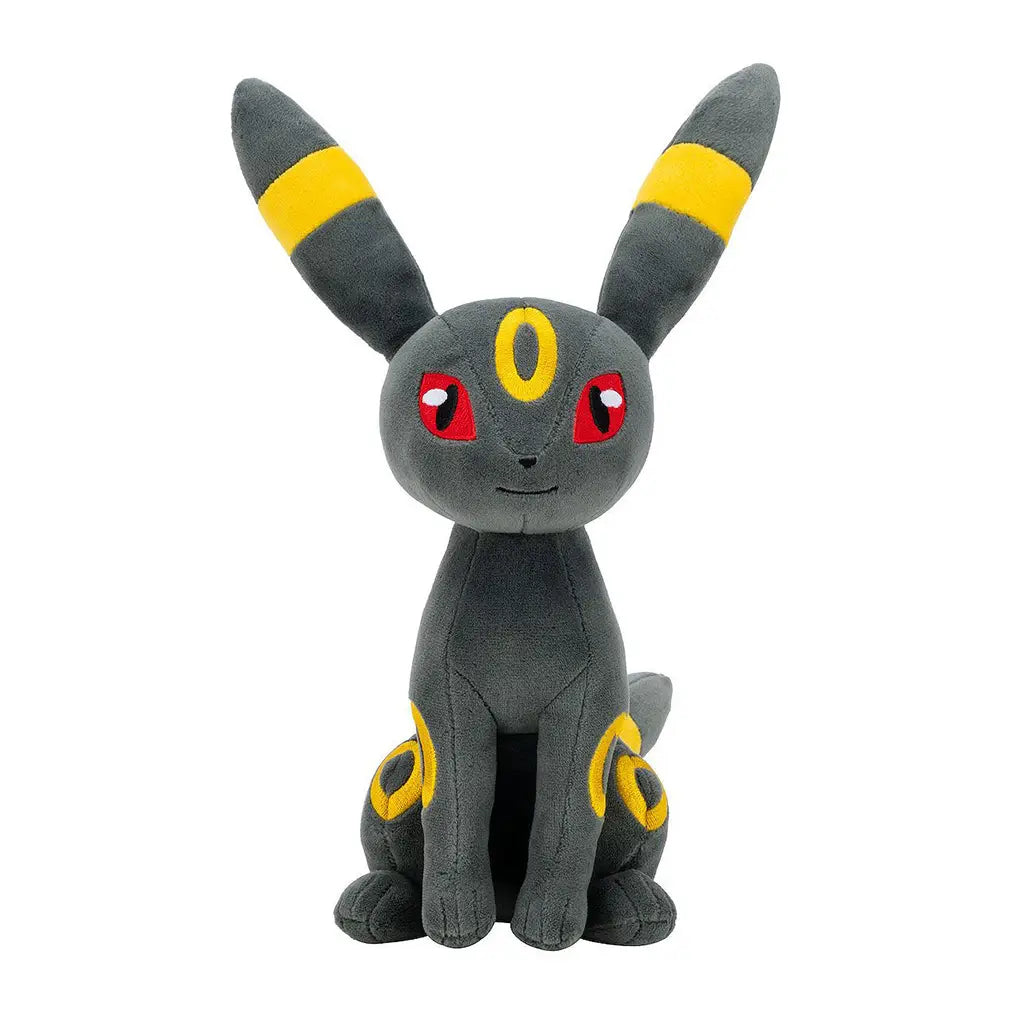 Pokémon Umbreon plush shows dark gray fabric with a soft velvety texture, slender feline-like form with bold yellow ring accents, conveying a sleek collectible theme against a simple white backdrop.