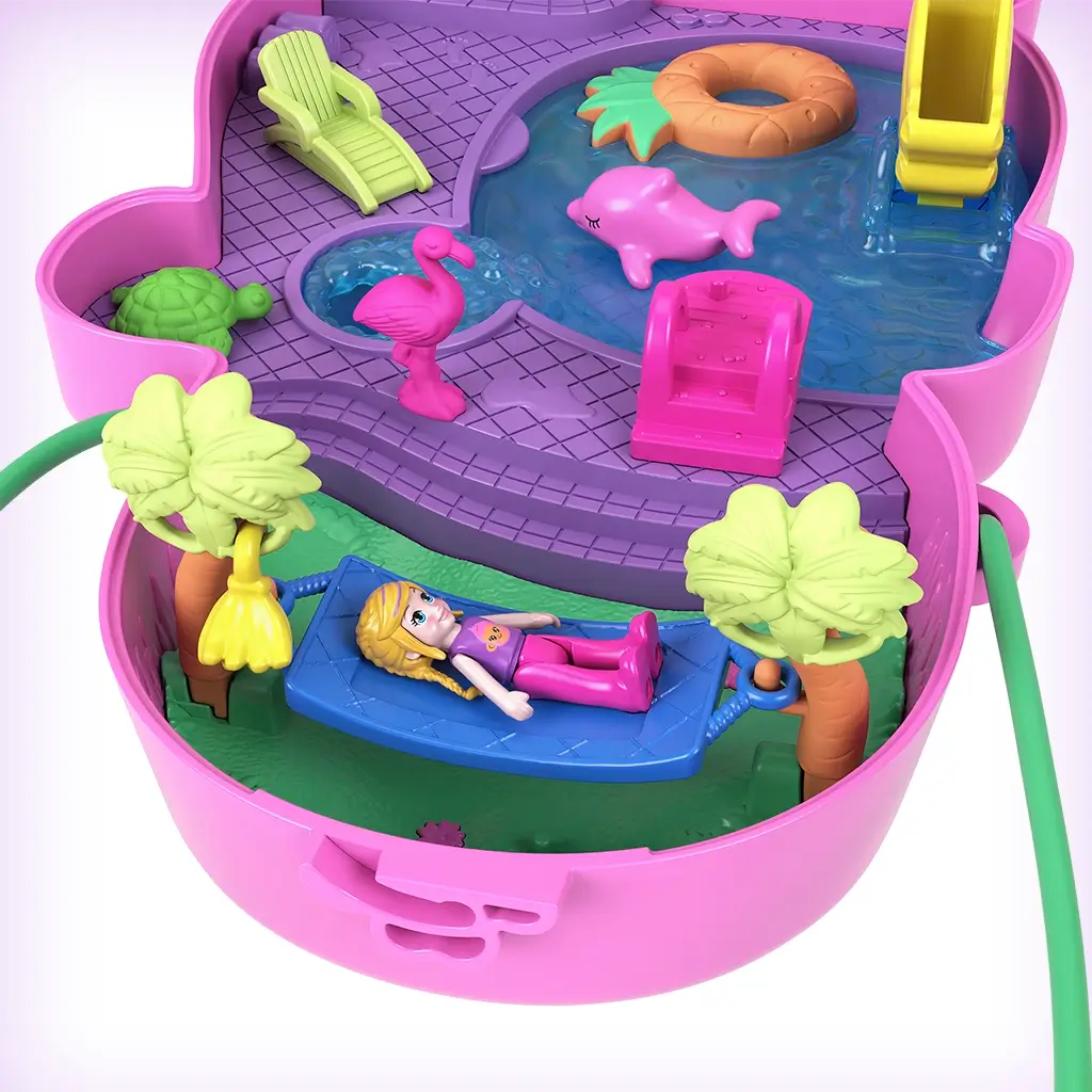 Polly Pocket playset interior showing purple base with water area, hammock between palm trees, flamingo, turtle, and doll relaxing under a tropical jungle backdrop.