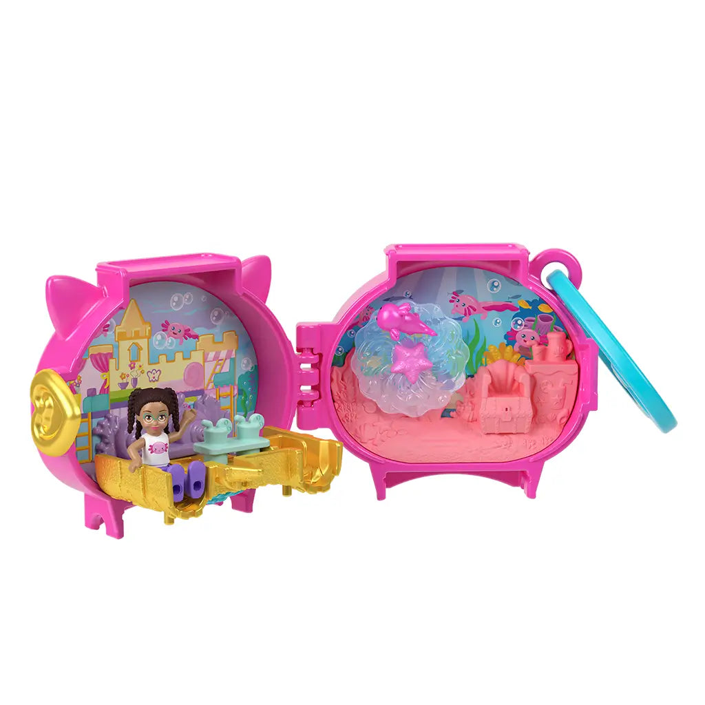 Polly Pocket axolotl locket playset opens to reveal pink compact with dual sides, one featuring gold castle furniture and the other showing underwater coral scene with rotating water piece.