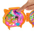 Child’s hand interacting with Polly Pocket fox locket playset, pressing butterfly feature as doll and fox figure rest inside detailed woodland scene with trees, flowers, and colorful designs.