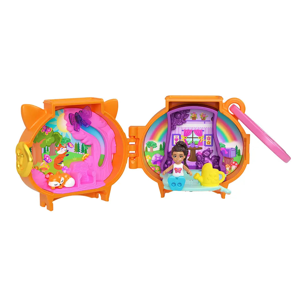 Fully opened Polly Pocket fox locket playset in orange plastic revealing two detailed scenes: a pink woodland with fox and butterflies, and a purple rainbow room with doll, watering can, and play features.