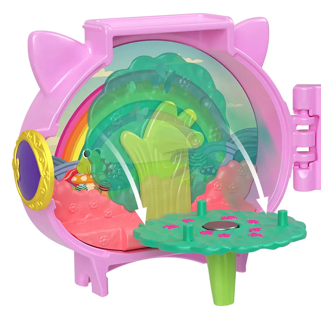 Interior of Polly Pocket unicorn locket featuring green tree stand that pivots, pink flowered seating, rainbow backdrop, and illustrated frog with mushroom scenery.