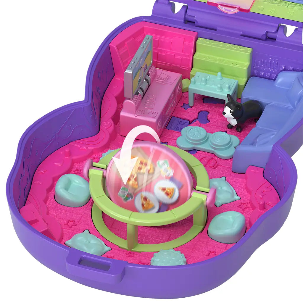 Interior of Polly Pocket Sleepover Puppy playset showing rotating green and pink table with pizza graphics, toy dog, and mini furniture pieces.