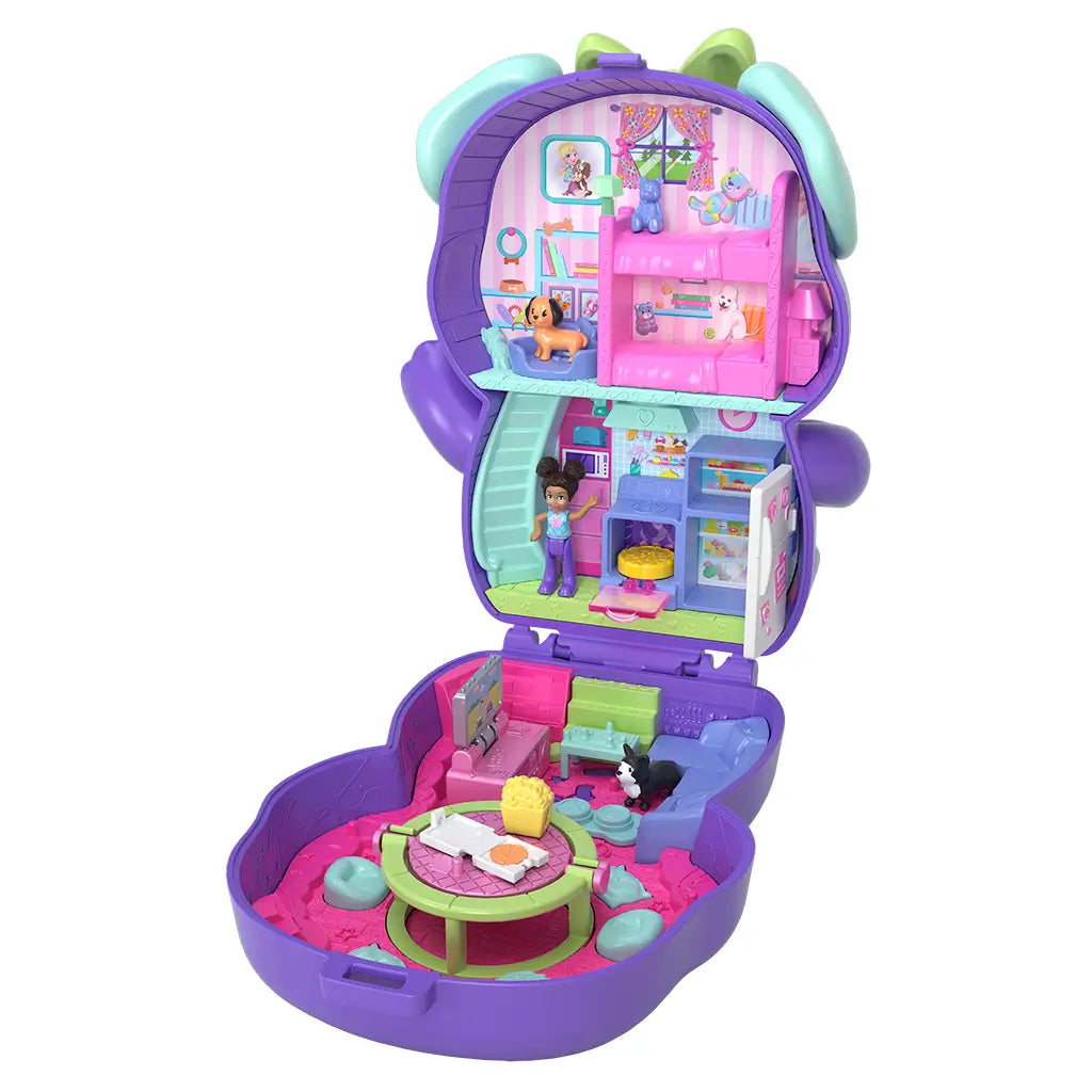 Open Polly Pocket Sleepover Puppy compact showing colorful two-story interior with bedroom, kitchen, lounge area, dolls, pets, and accessories.