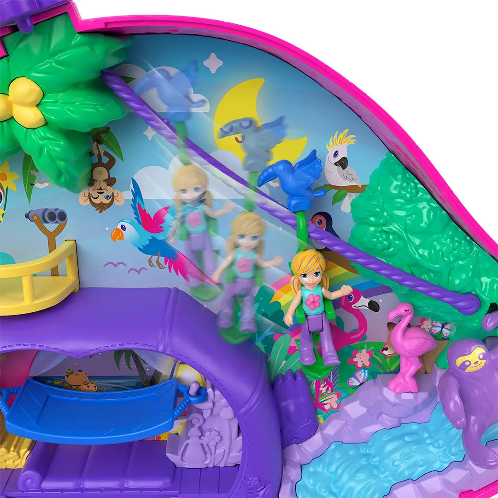 Close-up of Polly Pocket jungle compact playset with doll figure sliding on a purple zipline among colorful rainforest animals, trees, and illustrated background details.