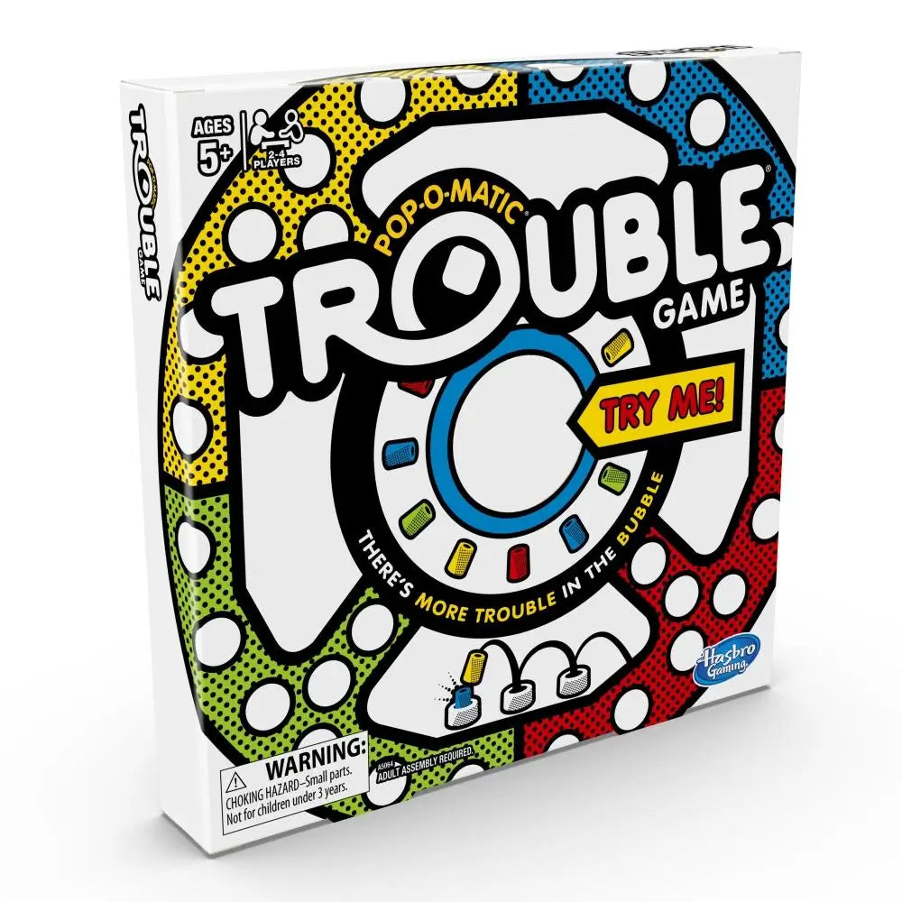 Pop-O-Matic Trouble board game box displaying a white cardboard package with bold black outlines, red, blue, yellow, and green graphics, circular track artwork, Hasbro branding, and a Try Me callout on the front panel.