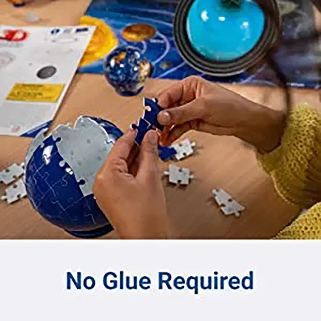 Child assembles dark blue Ravensburger puzzle pieces into a spherical globe, demonstrating sturdy interlocking design with no glue required for completion.