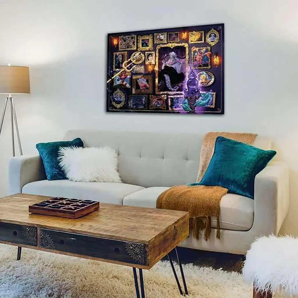 Completed Disney Villainous Ravensburger puzzle framed on a wall above a modern white sofa with teal pillows, glowing with vivid Ursula-themed artwork in gold-trimmed frames.