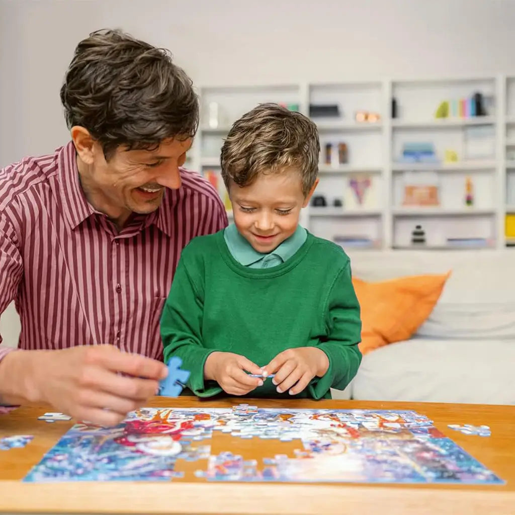 Smiling father and young son sit at a wooden table working on a Ravensburger Encanto puzzle, bonding while assembling colorful pieces in a cozy living room.