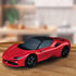 Completed Ravensburger Ferrari SF90 Stradale 3D puzzle sits on a wooden surface, showing detailed red car model at an angle.