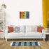 Modern living room with a white sofa, orange pillows, and a striped rug features the completed Ravensburger Floral Reflections puzzle framed on the wall.