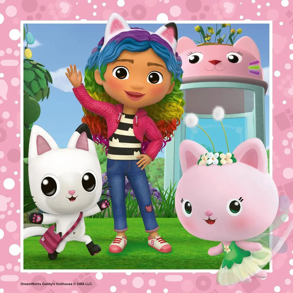 Cartoon girl Gabby with rainbow-colored hair poses outdoors with two cat friends and a fairy cat in a vibrant garden, from Gabby’s Dollhouse puzzle art.