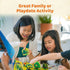 Two children smile and play Ravensburger Garden Heist together, lifting bright cardboard tree pieces on a vibrant garden board, promoted as a fun family or playdate activity.