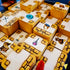 Close-up of Ravensburger 3D Labyrinth maze blocks featuring printed treasures like jewels, sword, potion, and chest, highlighting detailed artwork on stacked golden tiles.