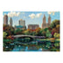 Completed Ravensburger puzzle image showing Central Park’s Bow Bridge in autumn with colorful trees, calm reflective water, rowboats, swans, and the New York skyline backdrop.