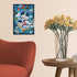 Completed Ravensburger Disney Mickey Mouse 300 piece puzzle framed on wall above wooden side table with glass vase of yellow flowers, next to red modern armchair.
