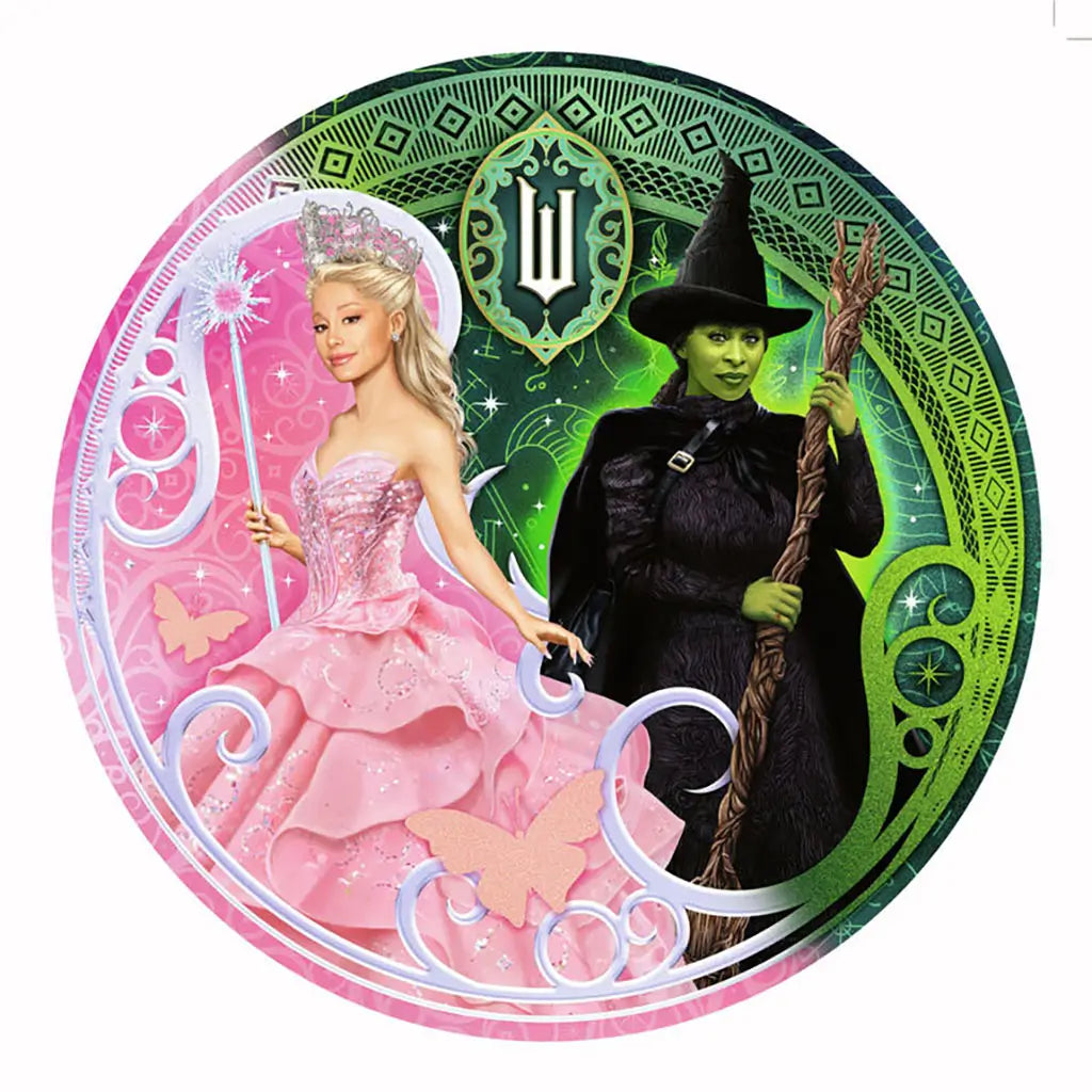 Round Ravensburger Wicked puzzle design depicts Glinda in a glittery pink ballgown with tiara and wand standing beside Elphaba in black with green skin, staff, and pointed witch hat.