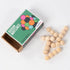 Beaded wooden brain teaser puzzle with interlinked spheres shown next to Brain Matches Puzzle Box #5 packaging featuring colorful circle illustration.