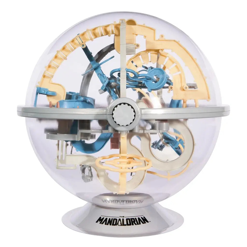 Rubik’s Tracks Mandalorian maze sphere shows a clear round plastic shell with interlocking blue, tan, and gray obstacle paths and an orange core, designed as a rotating 3D gravity puzzle.