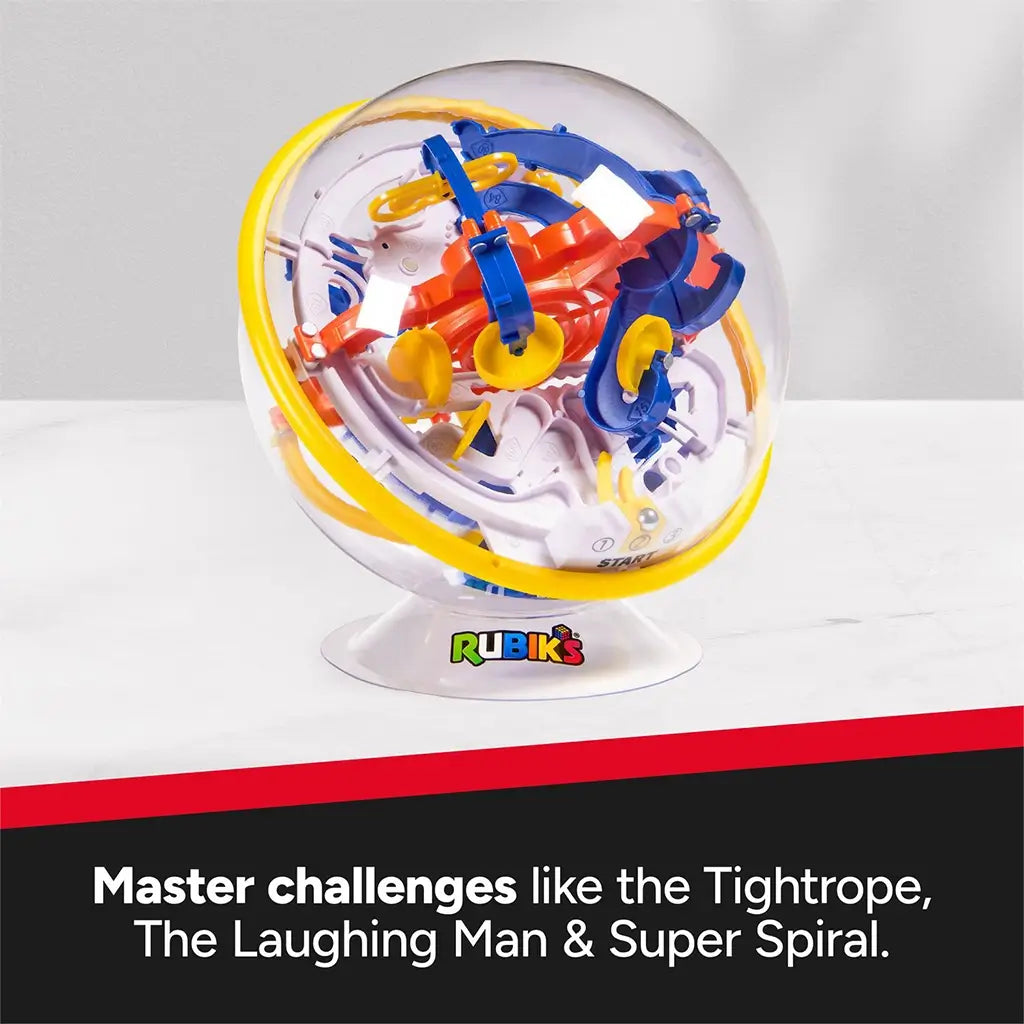 Rubik’s Tracks 3D gravity maze sphere shows a transparent plastic globe with yellow outer ring and blue, orange, and white track elements, highlighting advanced challenge features in a studio setting.