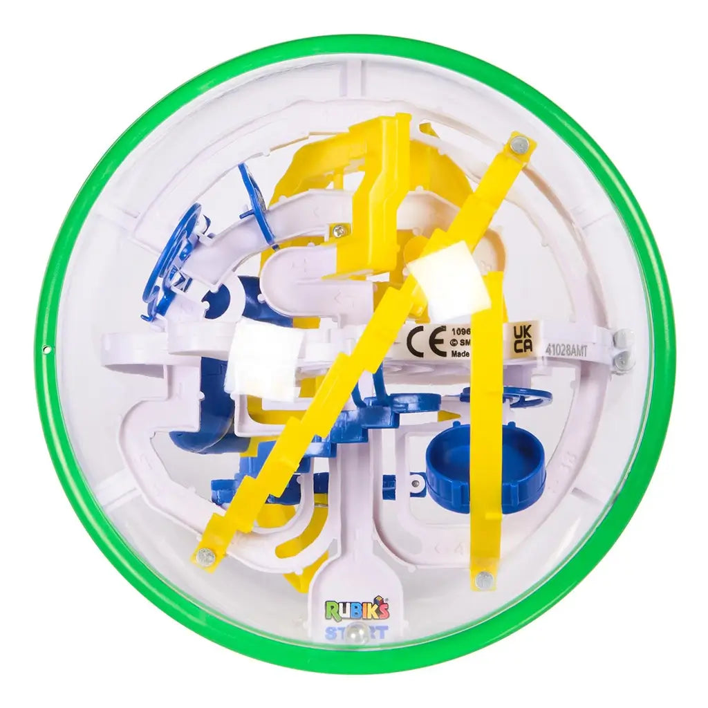 Rubik’s Tracks 70 obstacles top view shows a clear plastic globe with circular green rim and layered yellow bridges, blue curves, and white channels arranged in a compact 3D maze.