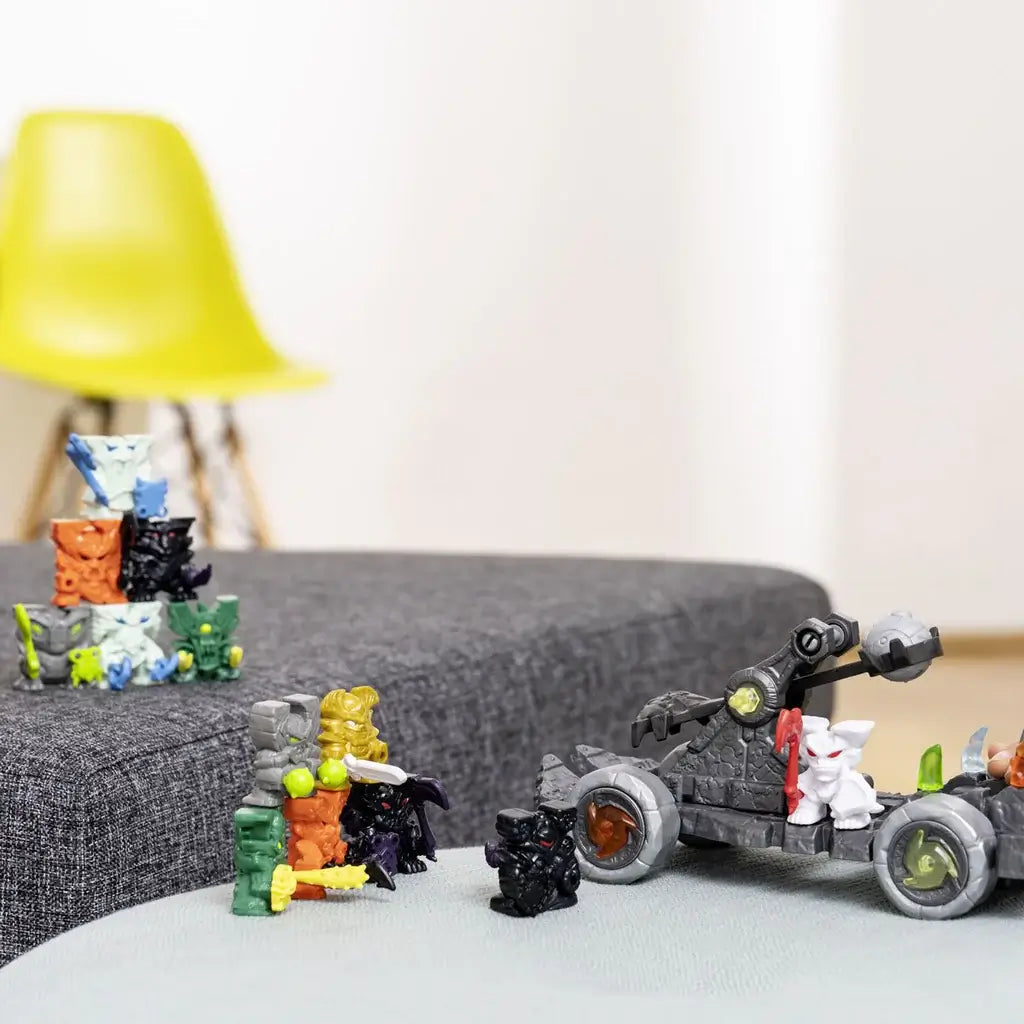 Schleich Eldrador catapult playset displayed in use, showing gray rock-style plastic vehicle, rolling wheels, functional throwing arm, mini creature figure, and additional Eldrador figures arranged on a tabletop play scene.