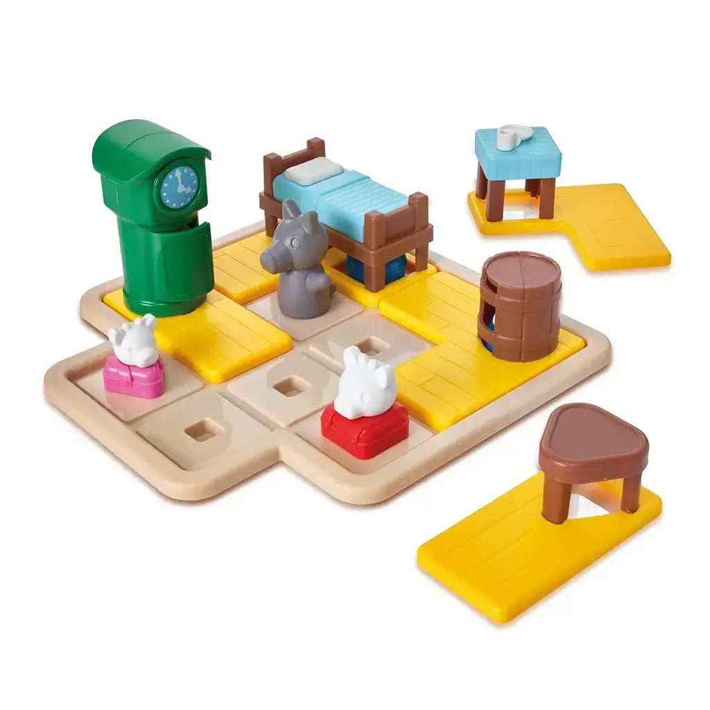 Smart Games Hide & Goat Seek puzzle set with colorful plastic pieces including goats, wolf, bed, table, barrel, and clock on a yellow-tiled board for preschool brain training.
