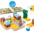 Smart Games Hide & Goat Seek puzzle set with board, animal and furniture pieces, shown with included illustrated picture book for storytelling and interactive preschool play.