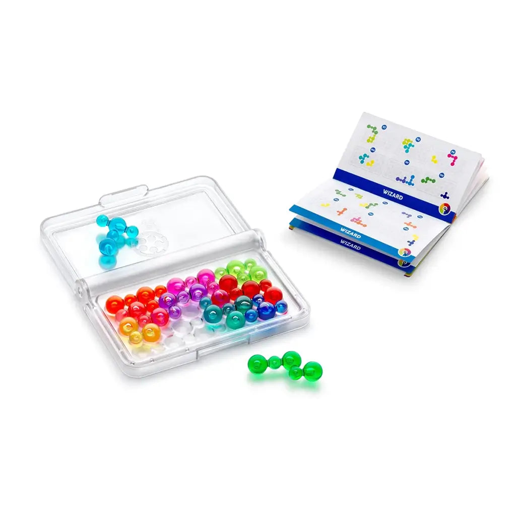 Transparent plastic case filled with multicolored bubble puzzle pieces shown beside an open Smart Games IQ Bubbles challenge booklet with bright diagrams and numbered grids.