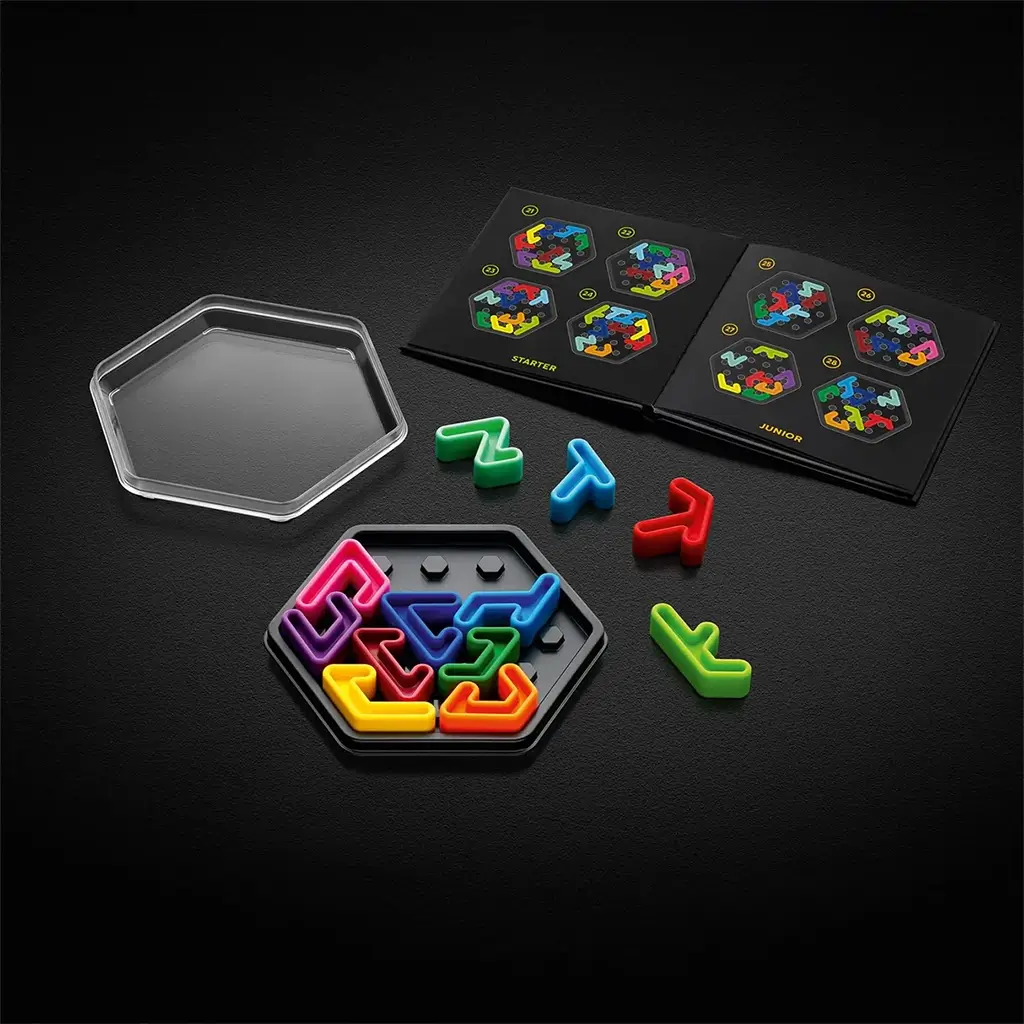 SmartGames IQ Hexagon set displayed with open hexagonal case, bright puzzle pieces, clear lid, and instruction booklet showing colorful starter challenges.
