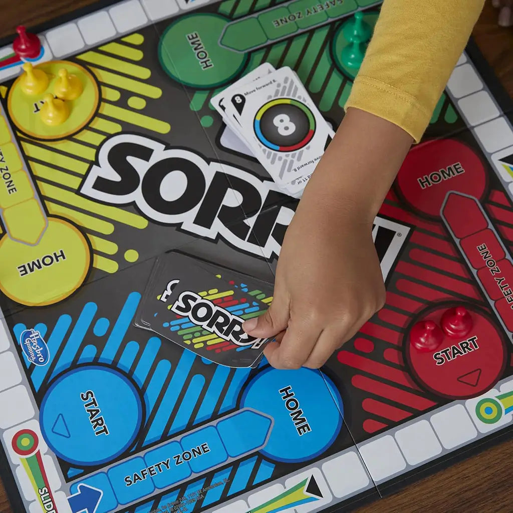 Sorry board game in use on a tabletop with bright multicolor pawns, laminated board, and card deck visible, photographed during active gameplay to demonstrate interactive family fun and turn-based movement mechanics.