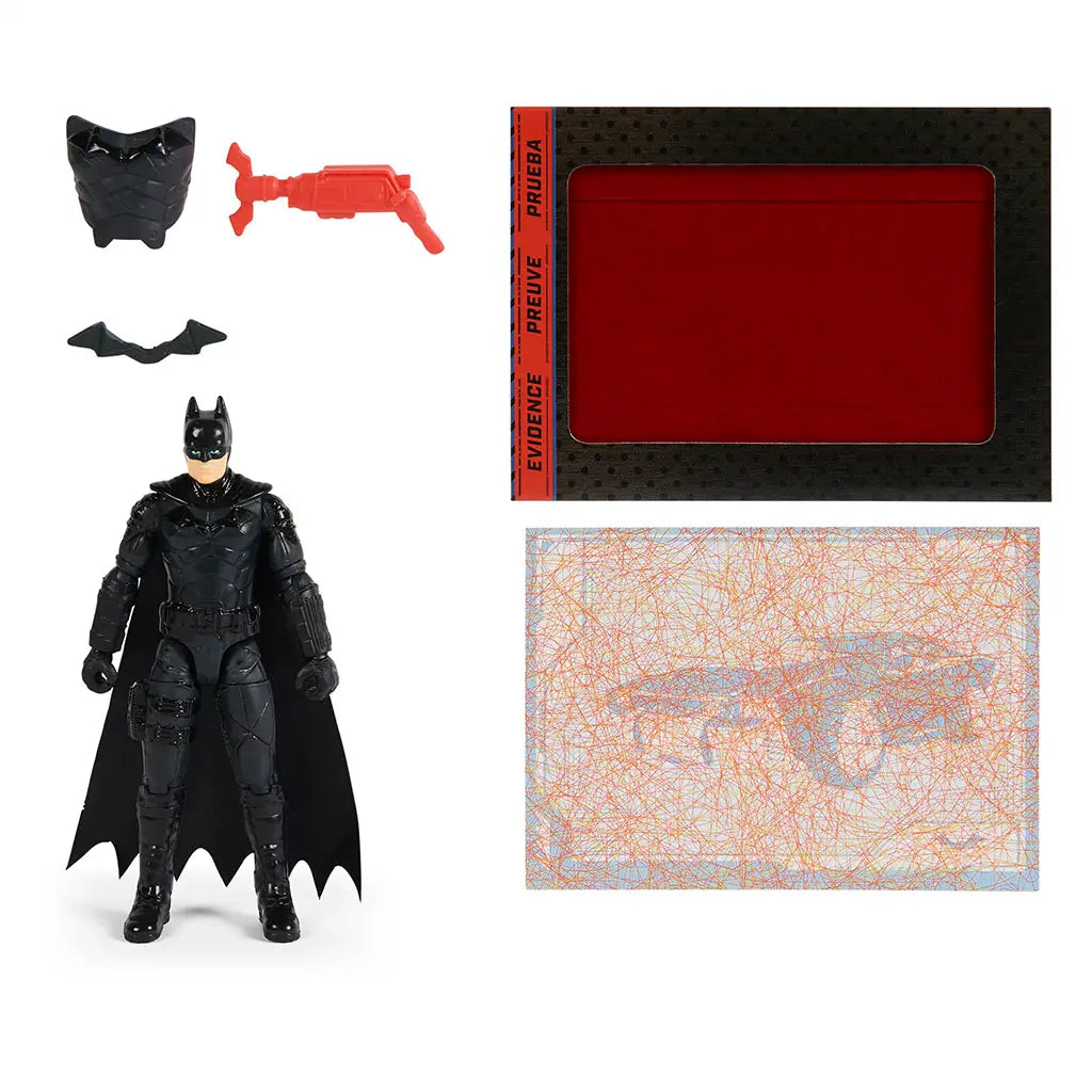 Black armored Batman action figure stands with removable accessories including red grappling gun, bat emblem, armor chest plate, and secret mystery card from set.