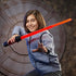 Child performing dynamic action stance with Star Wars Lightsaber Forge Darth Vader red lightsaber, gripping the hilt firmly and extending their free hand in a dramatic pose in a themed sci-fi space.