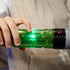 Star Wars Lightsaber Forge Sabine Wren glowing core feature, showing a child’s hand sliding a switch on the translucent green hilt as a bright green light shines from inside against a soft backdrop.