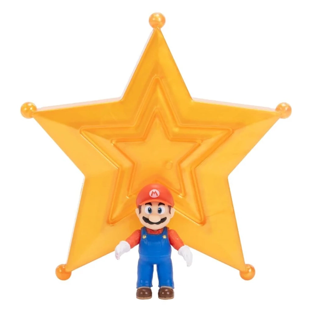 Super Mario Galaxy Movie Mario figure wears red and blue overalls with white gloves and brown shoes, standing before a large translucent orange-gold star on white.