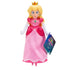 Princess Peach plush toy from The Super Mario Galaxy Movie features soft pink satin dress, blonde hair, gold crown, white gloves, blue jewelry, and retail tag on white.