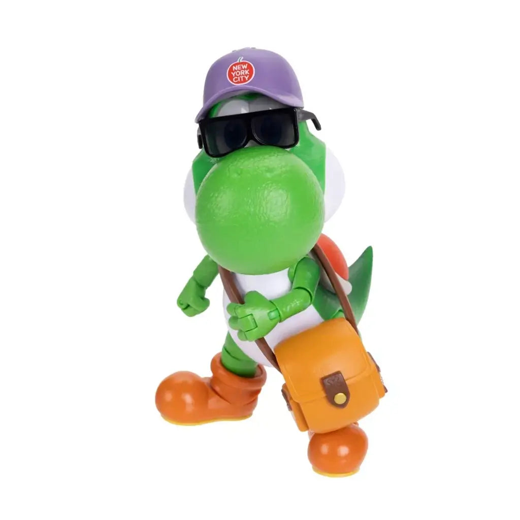 Super Mario Galaxy Movie Yoshi figure has green textured plastic, orange boots and bag, wearing a purple New York City cap and black sunglasses against a white backdrop.