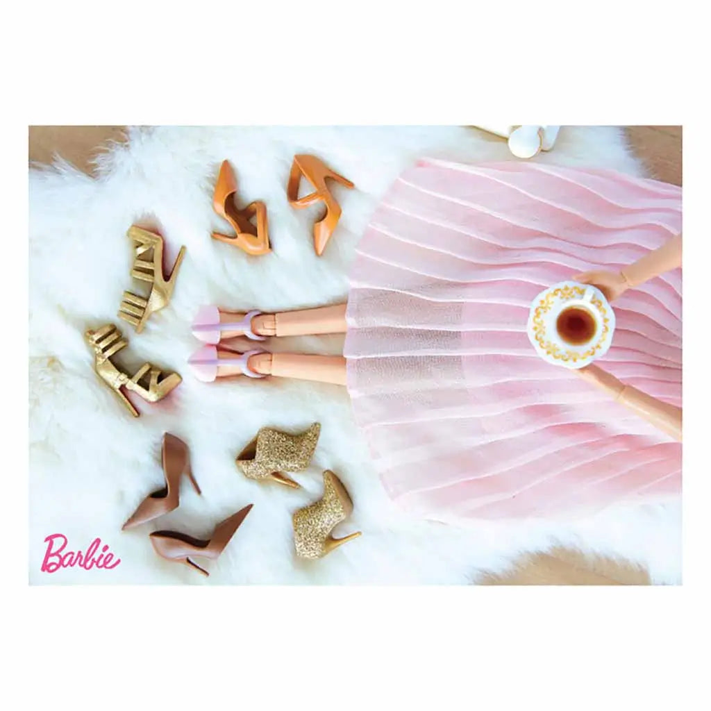 Flat lay image of a Barbie doll seated with crossed legs in a flowing pink skirt, holding tea while surrounded by stylish miniature high heels and glittery boots displayed on a soft fur background.