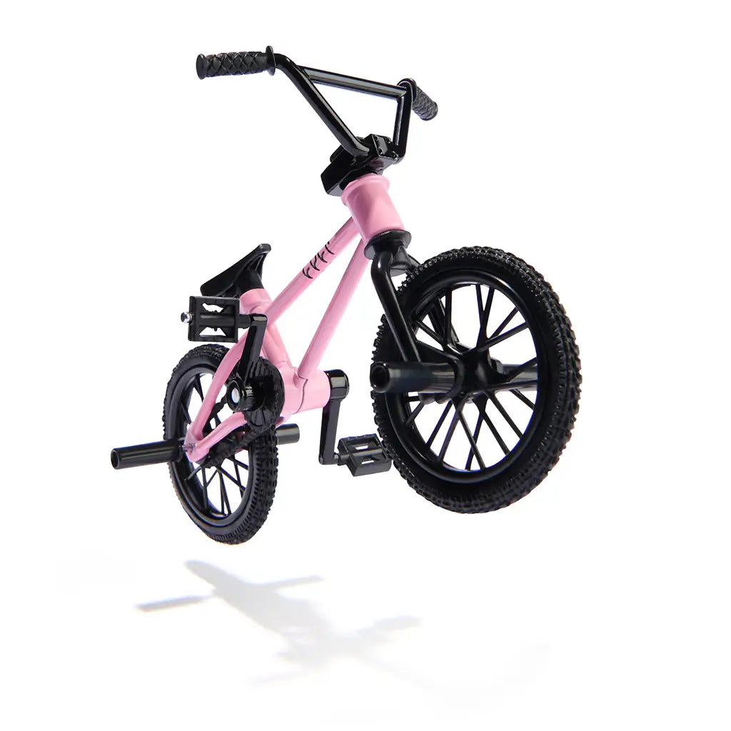 Tech Deck BMX finger bike in pink metal frame with black rubber tires and plastic details, angled compact stunt form with pegs and handlebars, designed for tricks on a minimal white studio background.