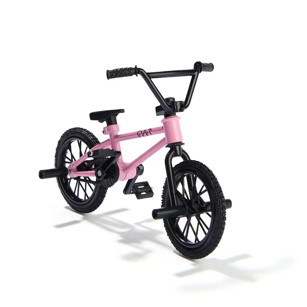 Tech Deck BMX finger bike in pink metal frame and black rubber tires, compact stunt bike shape with pegs, pedals, and handlebars, designed for freestyle tricks on a clean white background.